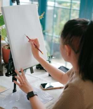 A girl paints in a sunlit studio